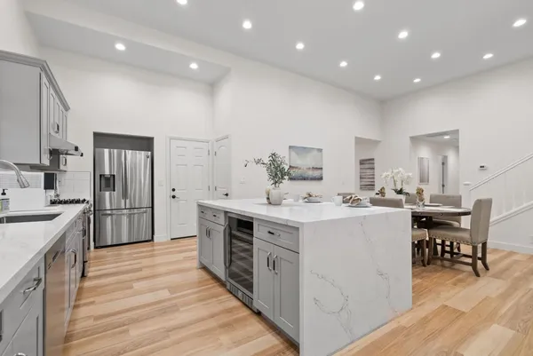 a large kitchen with stainless steel appliances a sink and cabinets