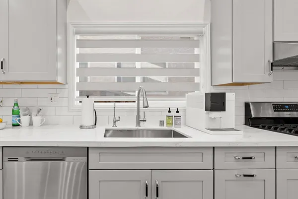 a kitchen with appliances a sink and cabinets