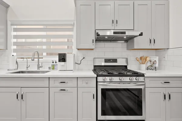a kitchen with white cabinets and appliances