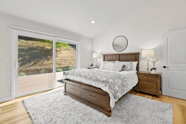 a bed sitting in a spacious bedroom next to a window