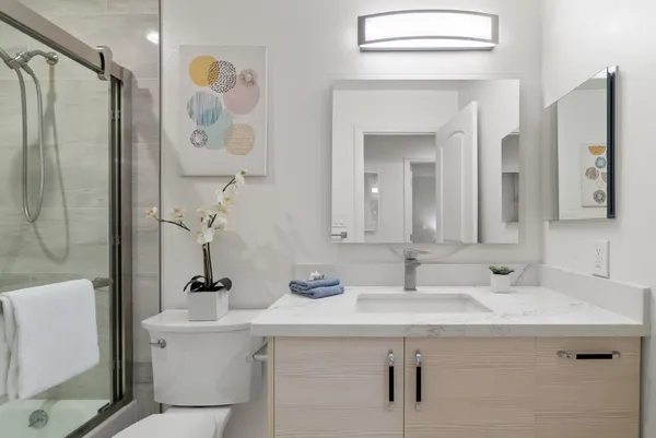 a bathroom with a sink and mirror with toilet