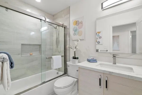 a bathroom with a sink mirror toilet and shower