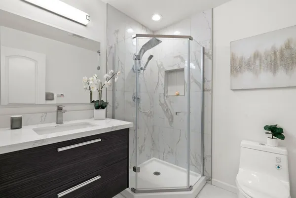 a bathroom with a shower sink and mirror