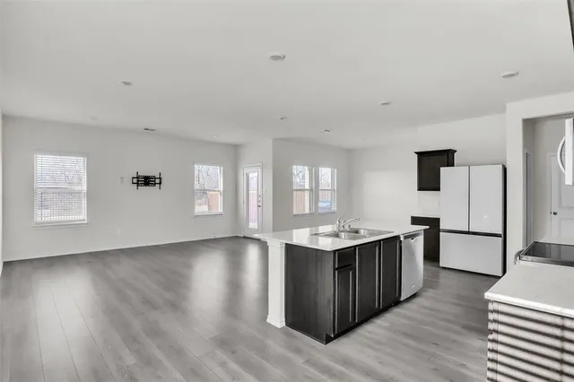 a kitchen with stainless steel appliances granite countertop a sink stove and wooden floor