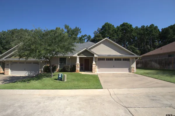 a front view of a house with a yard and trees