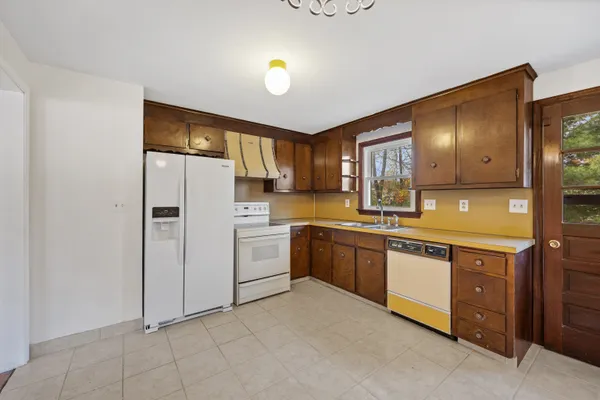 a kitchen with a sink refrigerator and cabinets