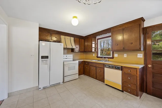 a kitchen with a sink refrigerator and cabinets