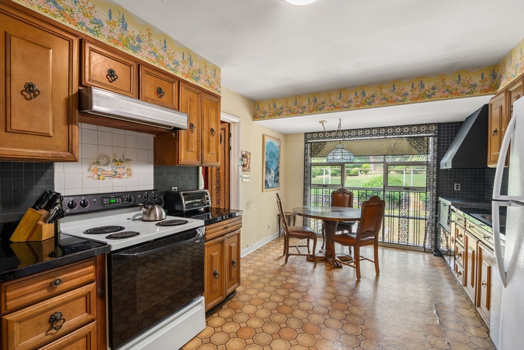 65 Lagrange Street Brookline, MA 02467 - Photo 16 of 39 a kitchen with stainless steel appliances granite countertop a stove and a refrigerator