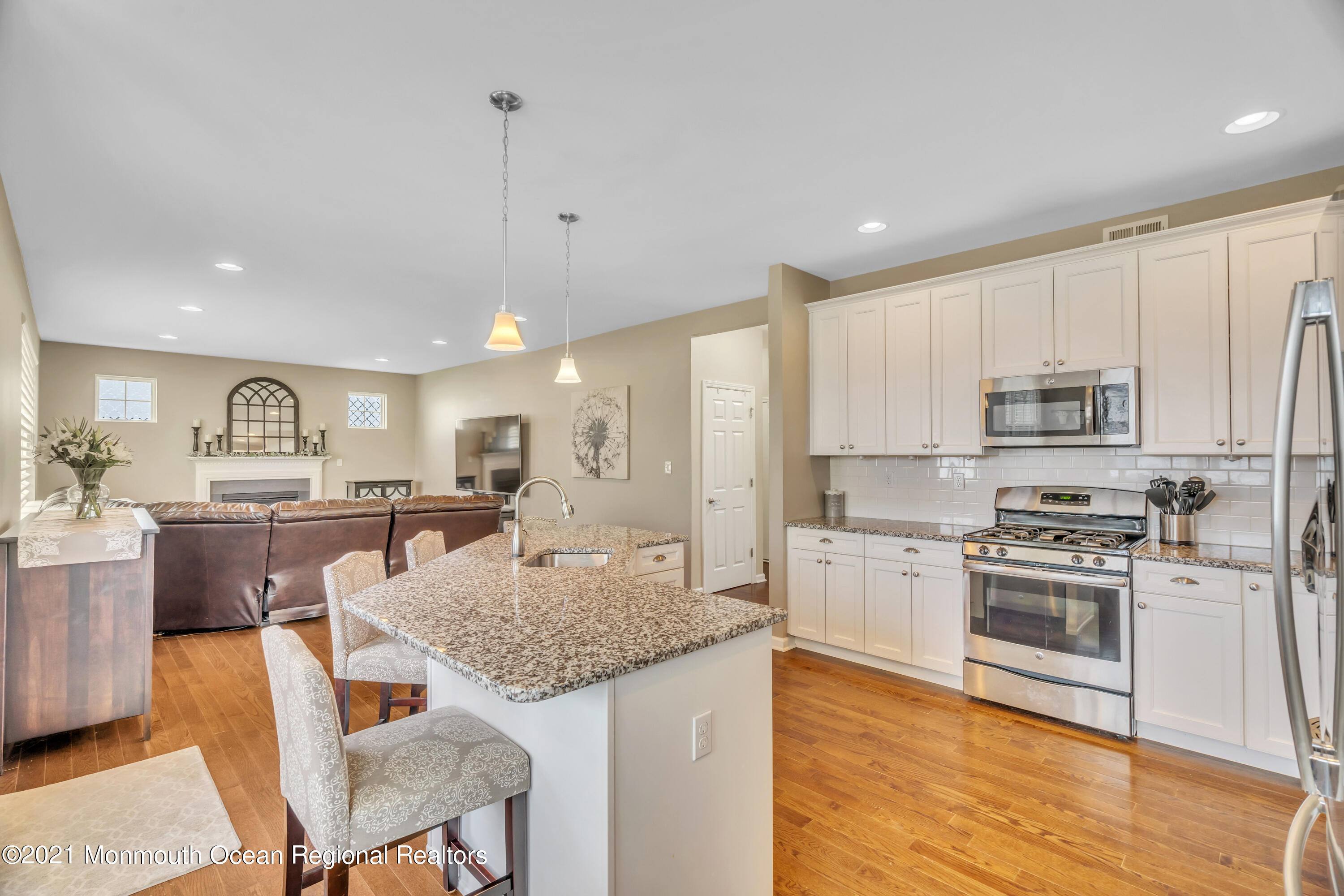 16 Bellagio Road Jackson, NJ 08527 - Photo 18 of 46 a kitchen with stainless steel appliances granite countertop a stove top oven a sink dishwasher and a refrigerator with wooden floor