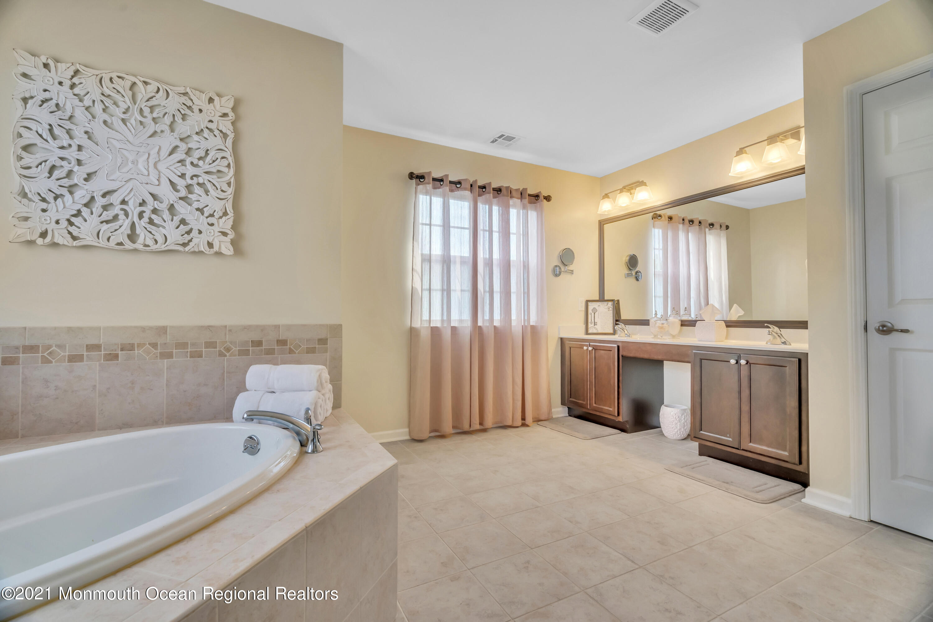 16 Bellagio Road Jackson, NJ 08527 - Photo 38 of 46 a bathroom with a tub a sink and a large mirror