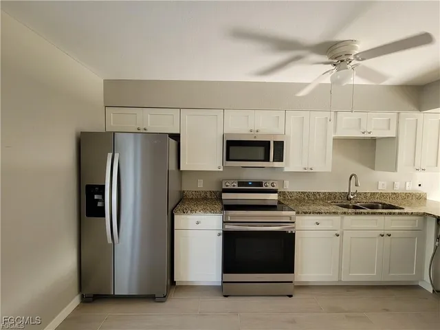 a kitchen with stainless steel appliances a stove a sink and a refrigerator