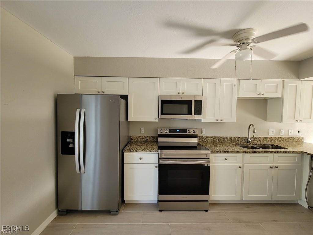 4530 Southwest 7th Place, Unit B Cape Coral, FL 33914 - Photo 3 of 18 a kitchen with stainless steel appliances a stove a sink and a refrigerator