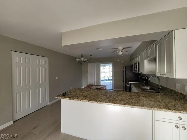 a view of a kitchen with granite countertop cabinets