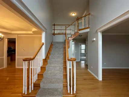 a view of a hallway with wooden floor and staircase
