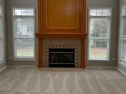 a view of an empty room with a fireplace and a window