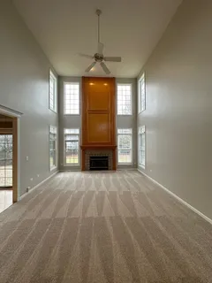 a view of empty room with a fireplace and windows