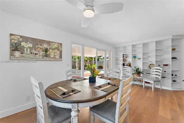 a dining room with furniture a large window and wooden floor