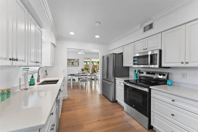 a kitchen with stainless steel appliances granite countertop a refrigerator stove microwave and cabinets