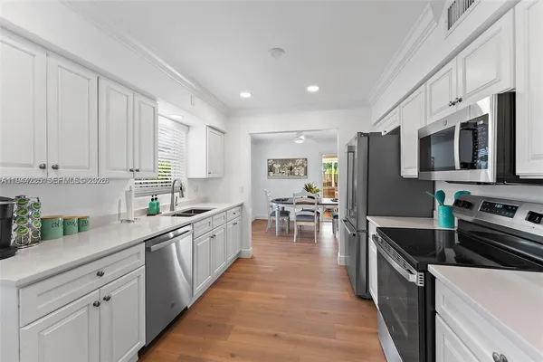 a kitchen with stainless steel appliances a stove sink microwave and cabinets