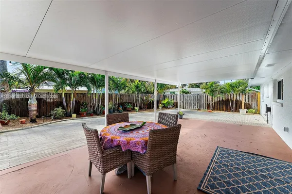 a view of a patio with table and chairs potted plants with wooden fence