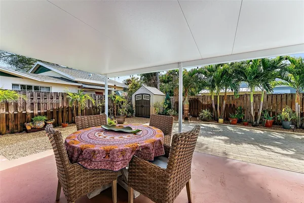 a view of a patio with a table chairs and a backyard