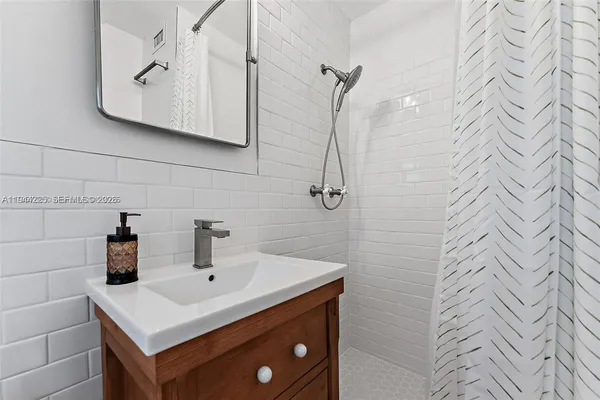 a bathroom with a sink a vanity and shower curtain