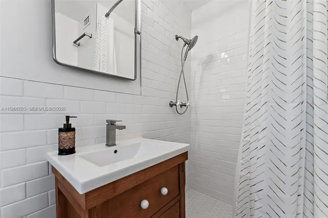 a bathroom with a sink a vanity and shower curtain