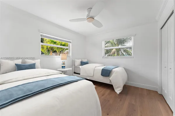 a bedroom with two beds and a large window