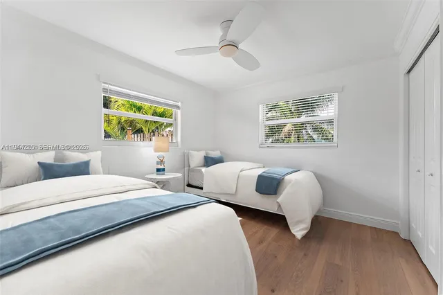 a bedroom with two beds and a large window
