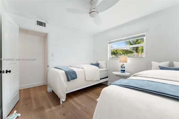 a spacious bedroom with two beds and a window