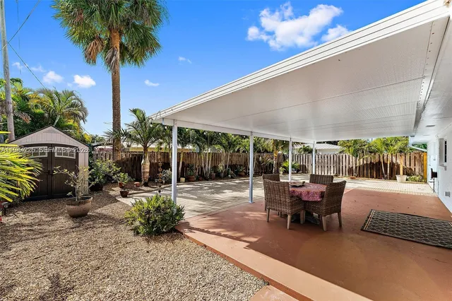 a view of a patio with a table and chairs under an umbrella
