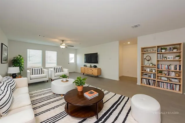a living room with furniture and a wooden floor
