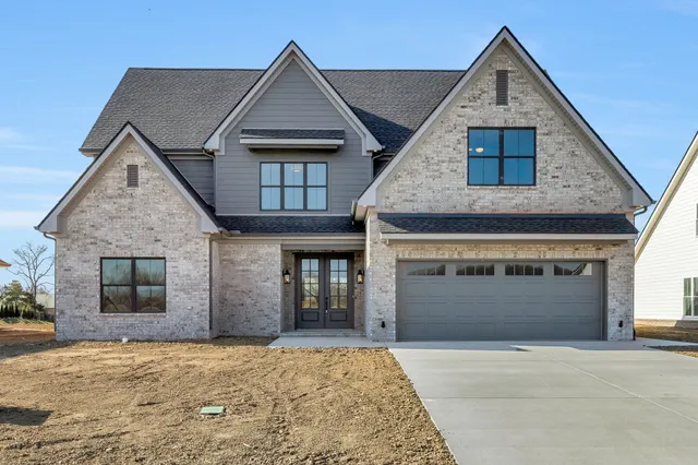 a front view of a house with a yard and garage