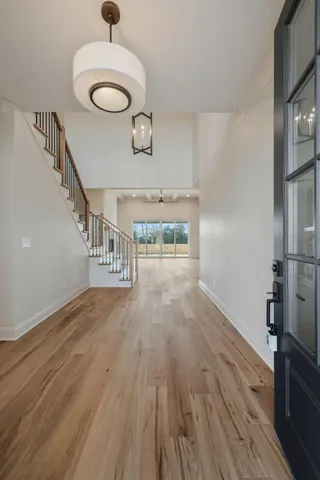 an empty room with wooden floor fireplace and windows