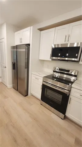 a kitchen with stainless steel appliances a stove a refrigerator and cabinets