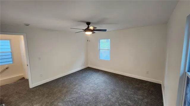 a view of an empty room and a ceiling fan