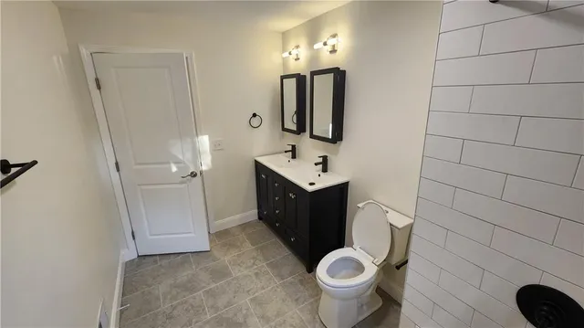 a bathroom with a double vanity sink toilet and shower