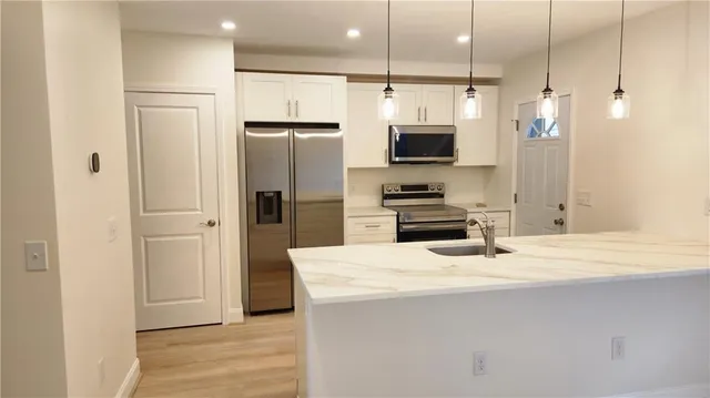 a kitchen with stainless steel appliances a refrigerator stove and microwave