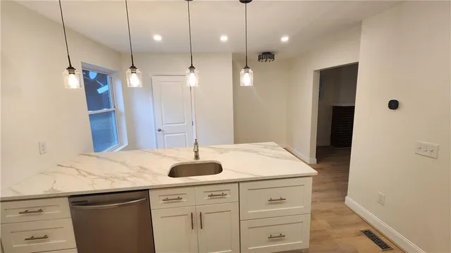 a kitchen with a sink chandelier and refrigerator