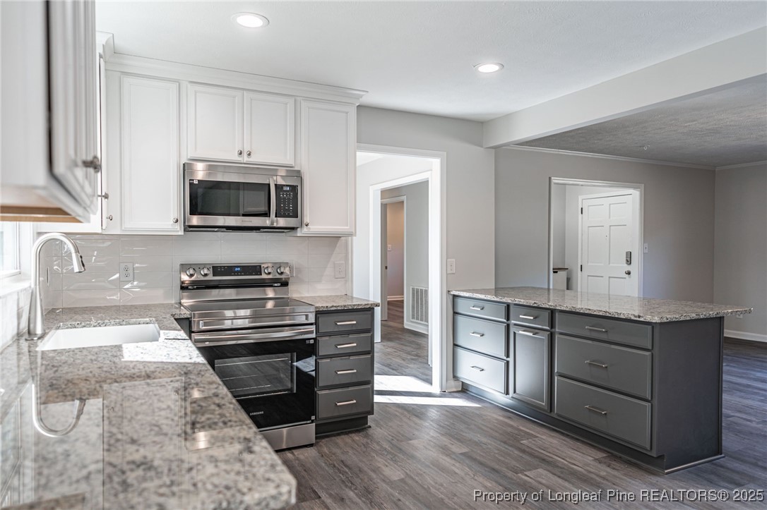 255 Foxcroft Road Whispering Pines, NC 28327 - Photo 8 of 31 a kitchen with a sink stove and microwave