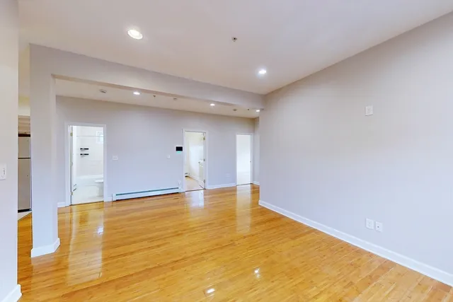 a view of empty room with wooden floor