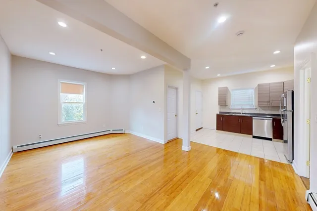 a large room with stainless steel appliances kitchen island a large counter top and a wooden floors