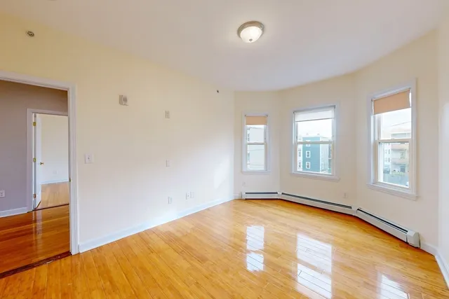 a view of empty room with wooden floor