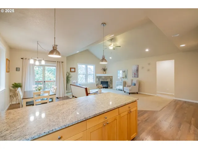 a view of a kitchen with kitchen island a large counter space a sink appliances and a living room view