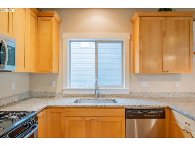 a kitchen with granite countertop cabinets sink and window