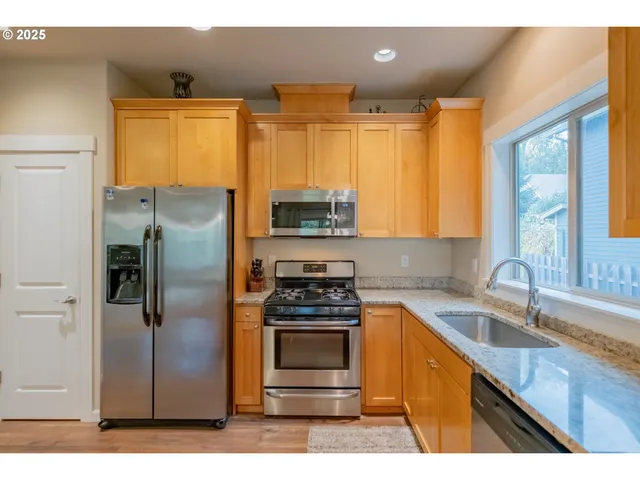 a kitchen with granite countertop a refrigerator and a sink