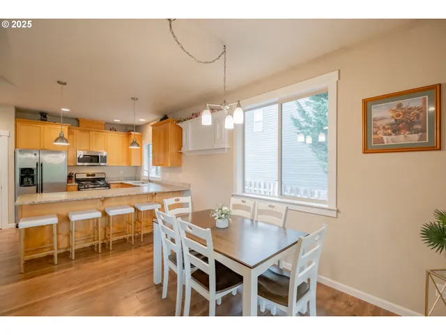 a kitchen with stainless steel appliances a table and chairs in it
