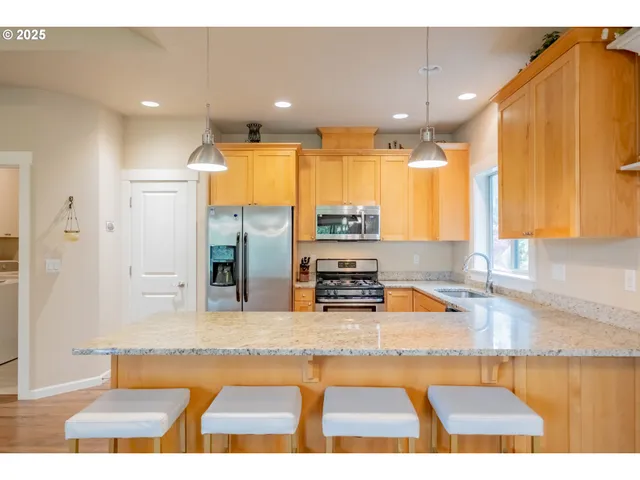 a kitchen with stainless steel appliances kitchen island granite countertop a refrigerator and a counter top