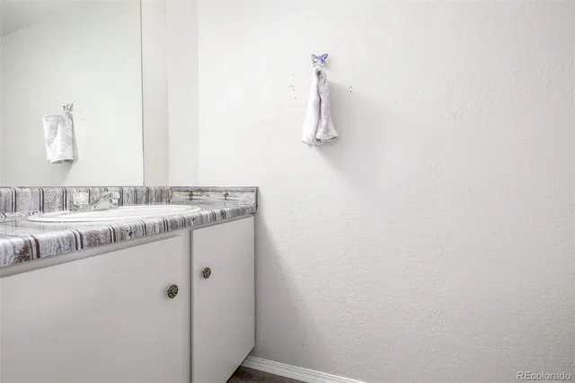 a bathroom with a granite countertop sink and vanity