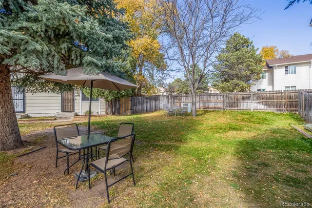 a view of a house with a yard and sitting area